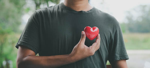 Man holding a plastic heart to his chest