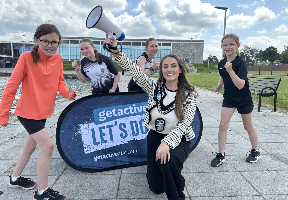 Group of people in running pose with the Lord Mayor Councillor Sarah Duffy holding a megaphone in the air