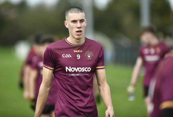 Young male gaelic footballer wearing a maroon jersey.
